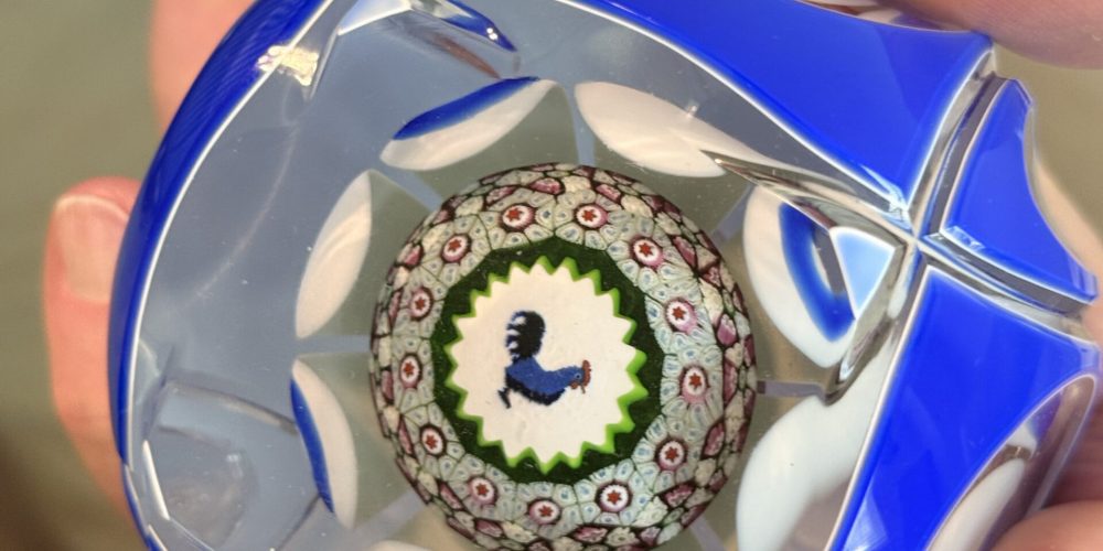 Roger G Jacobsen holding paperweight.